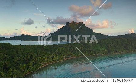 Bora Bora tropical paradise aerial landscape, breathtaking perspective of mount Otemanu, crystal lagoon, palm tree forest under gorgeous pink hues sunset. Explore French Polynesia travel destination Bora Bora tropical paradise aerial landscape, breathtaking perspective of mount Otemanu, crystal lagoon, palm tree forest under gorgeous pink hues sunset. Explore French Polynesia travel destination 120610777