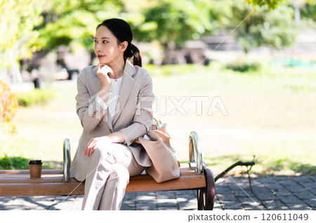 穿著西裝在公園長椅上思考的女商人 120611049