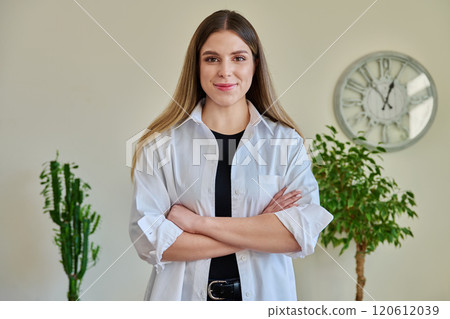 Confident young woman with crossed arms in home interior Confident young woman with crossed arms in home interior 120612039