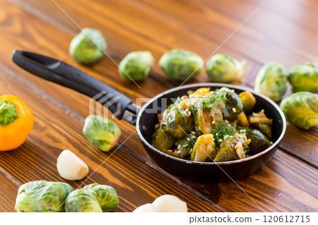 Brussel sprouts cooked with vegetables and spices, on a wooden table Brussel sprouts cooked with vegetables and spices, on a wooden table 120612715