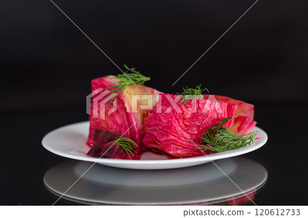 pickled cabbage with beets and carrots, in a plate, isolated on black background 120612733