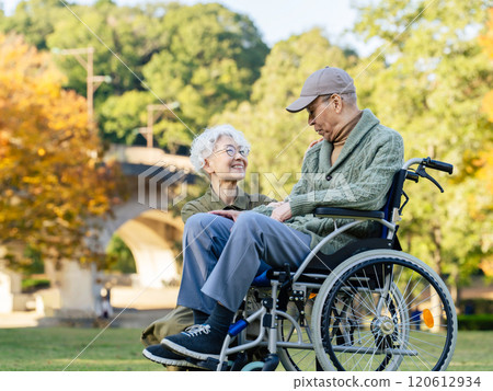 Senior couple: man in wheelchair and woman assisting him 120612934