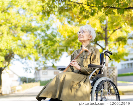 坐輪椅的資深婦女拄著拐杖 120612949