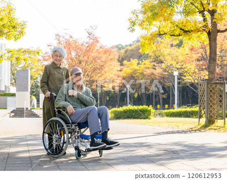 Senior couple: man in wheelchair and woman assisting him 120612953