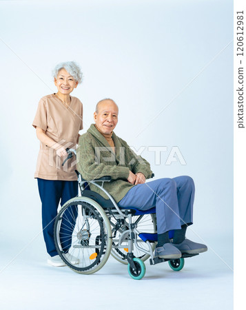 Senior man in a wheelchair and a female caregiver assisting him Senior man in a wheelchair and a female caregiver assisting him 120612981