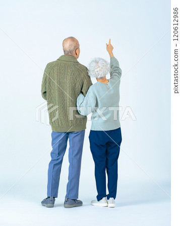 Full-body photo of a senior couple looking up from behind 120612986