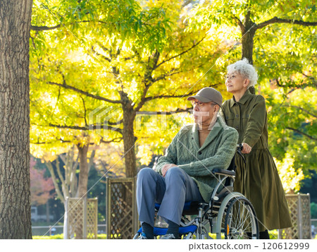 一對坐在輪椅上的男人和一位協助他的女人的年長夫婦 120612999