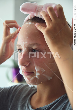 girl with a cosmetic mask on her face 120613380