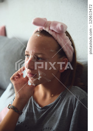 girl with a cosmetic mask on her face girl with a cosmetic mask on her face 120613472