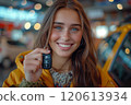 Caucasian woman showing car keys in hand sitting inside car in showroom. 120613934
