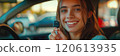 Caucasian woman showing car keys in hand sitting inside car in showroom. 120613935