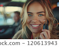Caucasian woman showing car keys in hand sitting inside car in showroom. 120613943