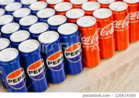 Kyiv, Ukraine - November 5, 2024: Close-up of neatly arranged Pepsi and Coca-Cola cans, showcasing a vibrant contrast of their iconic blue and red branding 120614160
