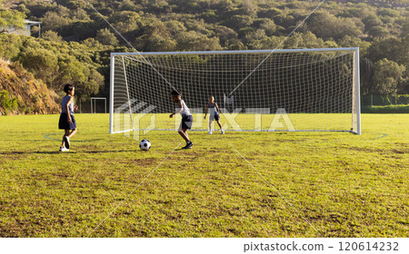 Outdoors, playing soccer on school field, multiracial boys practicing goalkeeping 120614232