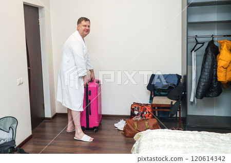 A man unpacks his things after a vacation trip 120614342