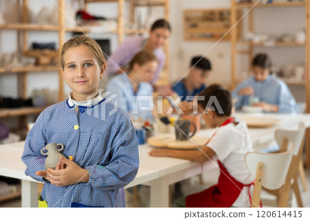 Little girl standing in art studio Little girl standing in art studio 120614415
