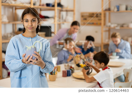 Preteen girl standing in art studio Preteen girl standing in art studio 120614463