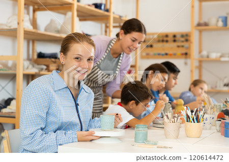 Teenage girl painting handmade ceramic cup with brush Teenage girl painting handmade ceramic cup with brush 120614472