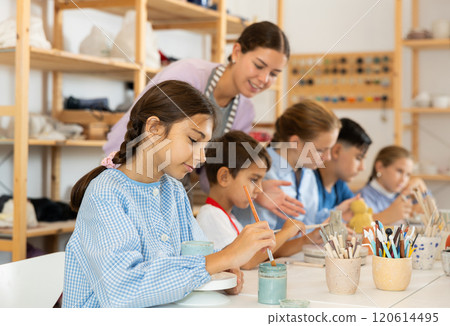 Girl paints ceramic dishes Girl paints ceramic dishes 120614495