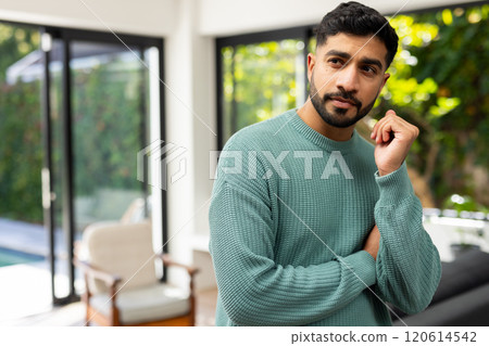 Thinking deeply, Indian man in green sweater standing indoors near large windows Thinking deeply, Indian man in green sweater standing indoors near large windows 120614542