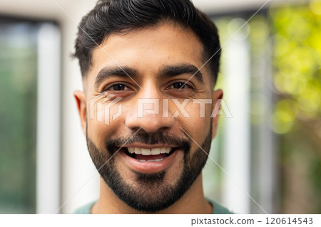 Smiling young Indian man looking at camera, close-up portrait in natural light Smiling young Indian man looking at camera, close-up portrait in natural light 120614543