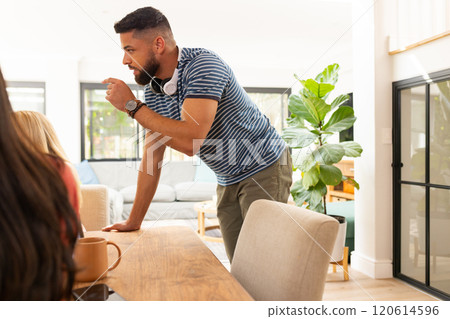 Start up business, Man leaning on table, talking to friends in casual home setting Start up business, Man leaning on table, talking to friends in casual home setting 120614596