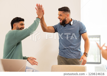 High-fiving, two young friends celebrating success with joy and excitement, start up business 120614616