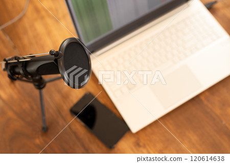 Podcasting setup with microphone, laptop, and smartphone on wooden desk, copy space Podcasting setup with microphone, laptop, and smartphone on wooden desk, copy space 120614638
