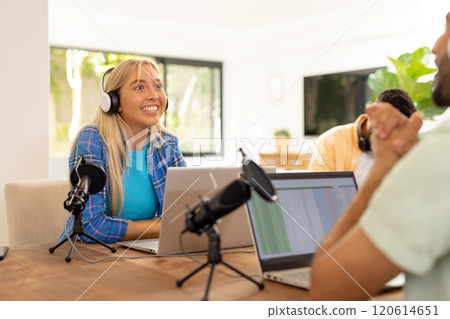 Recording podcast, woman wearing headphones and smiling with laptop and microphones Recording podcast, woman wearing headphones and smiling with laptop and microphones 120614651