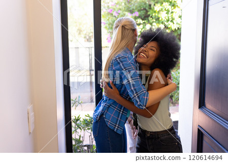 Hugging at doorway, young friends reuniting with joy and laughter Hugging at doorway, young friends reuniting with joy and laughter 120614694