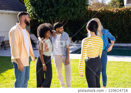 Standing together outside, friends enjoying conversation by pool Standing together outside, friends enjoying conversation by pool 120614716