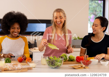 Preparing meal, young diverse friends chopping vegetables and laughing in kitchen Preparing meal, young diverse friends chopping vegetables and laughing in kitchen 120614739