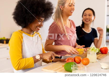 Preparing vegetables and enjoying cooking together, diverse friends in kitchen Preparing vegetables and enjoying cooking together, diverse friends in kitchen 120614746