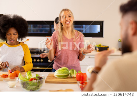 Cooking together, young diverse friends preparing vegetables and enjoying time in kitchen 120614748