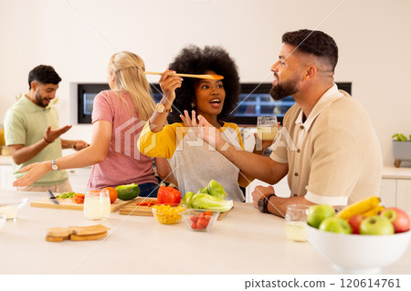 Friends cooking together in kitchen, enjoying food and drinks, having fun Friends cooking together in kitchen, enjoying food and drinks, having fun 120614761