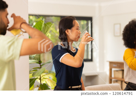 Friends drinking juice and socializing in modern living room together 120614791