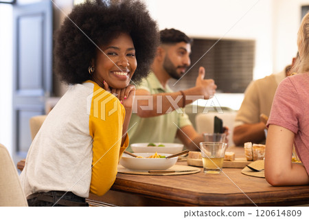 Enjoying meal with diverse friends, smiling woman socializing at dining table Enjoying meal with diverse friends, smiling woman socializing at dining table 120614809