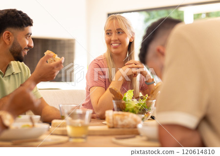 Eating lunch together, young diverse friends enjoying conversation and fresh salad 120614810