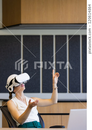 Using VR headset, woman in office interacting with virtual environment, copy space Using VR headset, woman in office interacting with virtual environment, copy space 120614864