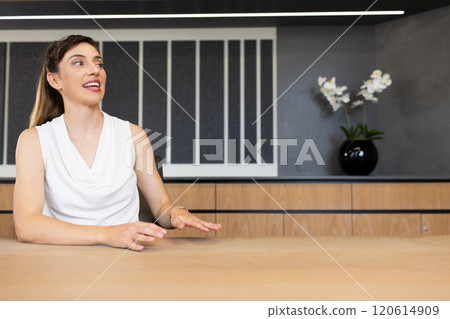 Businesswoman in white blouse sitting at table, engaging in conversation, copy space Businesswoman in white blouse sitting at table, engaging in conversation, copy space 120614909