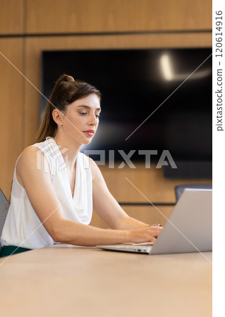 Working on laptop, businesswoman focusing on tasks in modern office setting 120614916