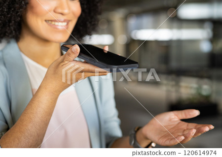 Holding smartphone, businesswoman smiling and using voice assistant in office Holding smartphone, businesswoman smiling and using voice assistant in office 120614974