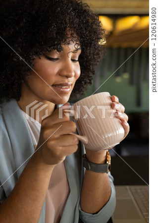 Holding coffee mug, woman enjoying break in office 120614980