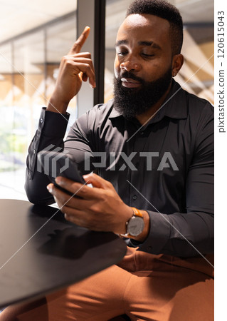 Using smartphone, businessman in black shirt focusing on work in office 120615043