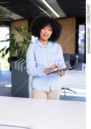 Using tablet, businesswoman standing in modern office, focusing on work Using tablet, businesswoman standing in modern office, focusing on work 120615447
