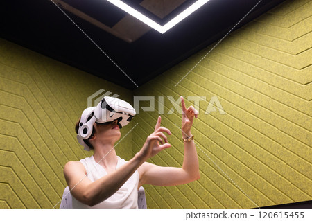 Using VR headset, woman interacting with virtual environment in modern office Using VR headset, woman interacting with virtual environment in modern office 120615455