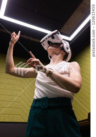 Using VR headset, woman interacting with virtual environment in modern office 120615459