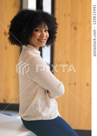 Smiling businesswoman in office, wearing polka dot blouse, arms crossed Smiling businesswoman in office, wearing polka dot blouse, arms crossed 120615491