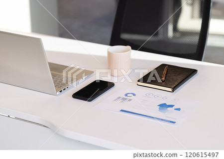 Laptop, smartphone, notebook, and coffee cup on modern office desk setup 120615497