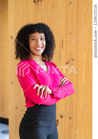 Confident businesswoman in pink blouse standing with arms crossed, smiling Confident businesswoman in pink blouse standing with arms crossed, smiling 120615516